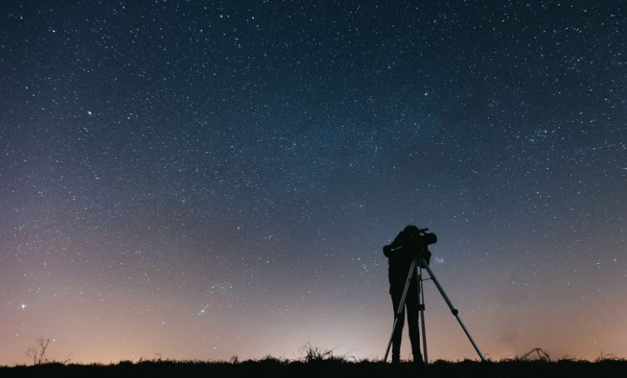 A person looking at the stars using a telescope