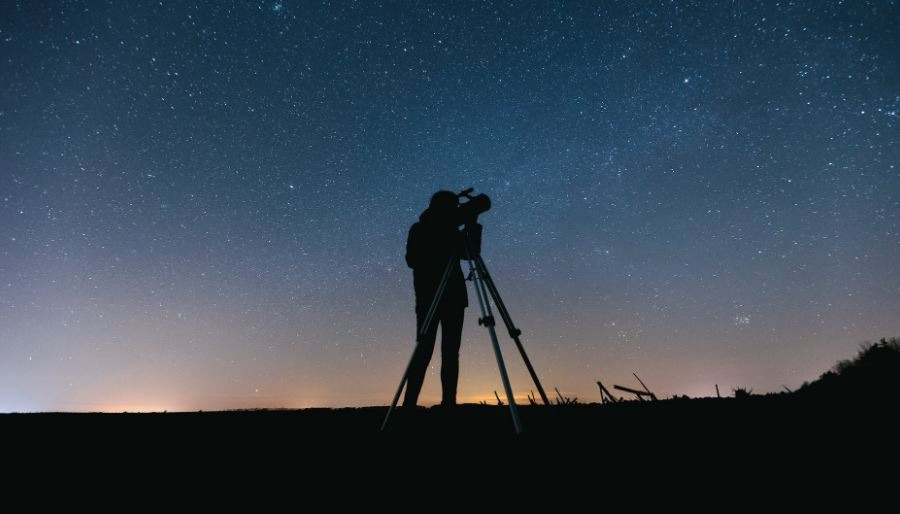 A man using a telescope for stargazing
