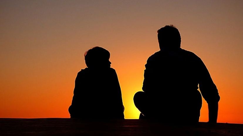 silhouettes of a father and his son, sunset