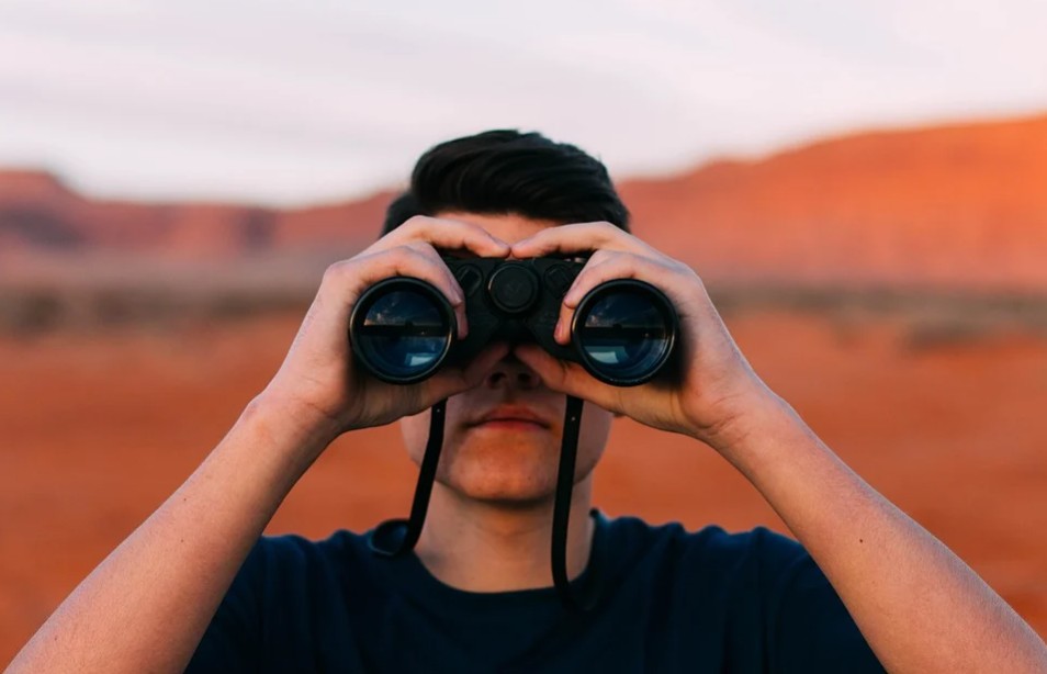 a man looking through his binoculars