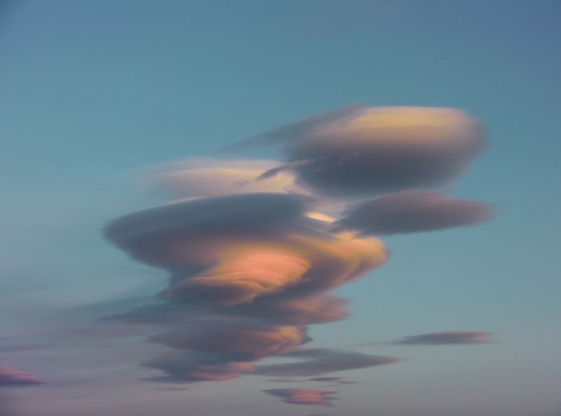 white clouds in a sky, lenticular, pinkish hue 