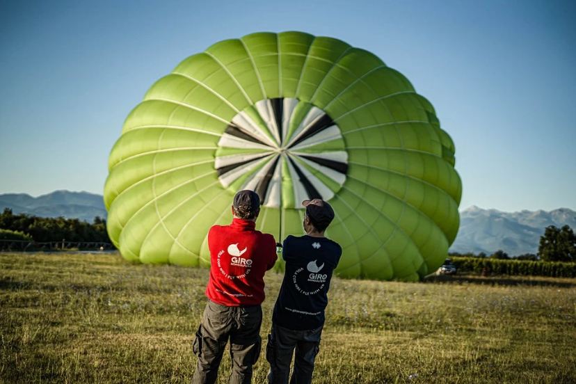 two men pulling a hot air balloon, hot air balloon, field