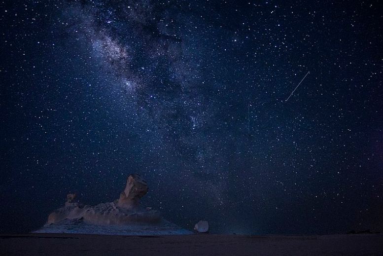 Perseids meteor, a single meteor heading to the ground, blue night sky, myriad stars, big rocks